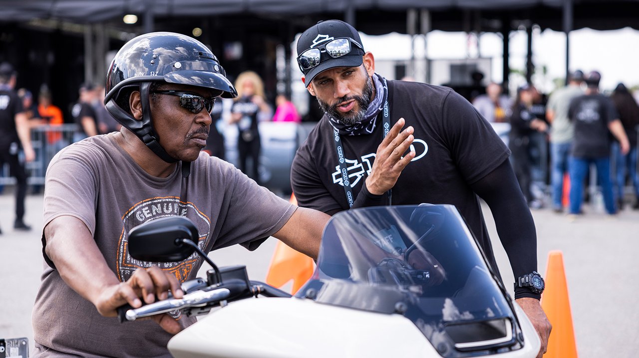 homem em uma motocicleta obtendo instruções com outro homem