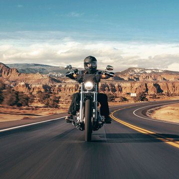 pilotando uma motocicleta em uma estrada no deserto