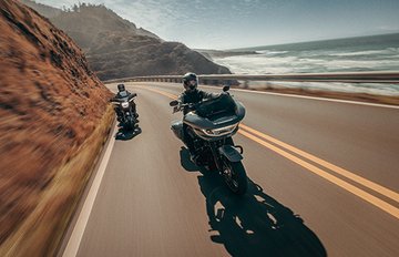 Two motorcycles riding on a road