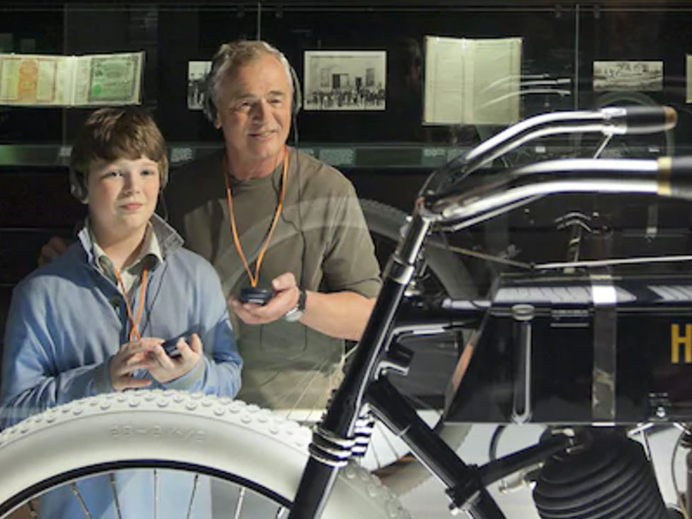 Man and young man taking the audio tour