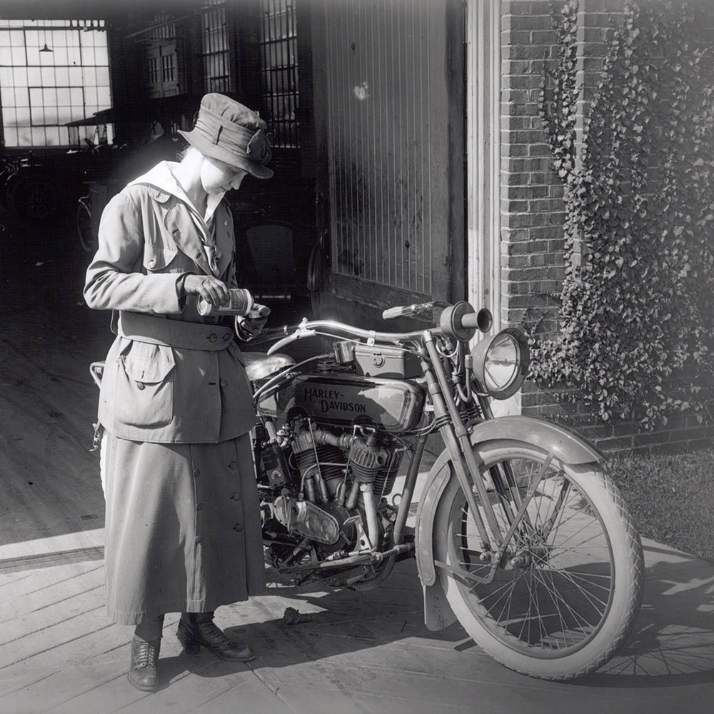 kvinde ved siden af motorcykel fra først i 1900-tallet