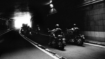 Motorcyclists riding through tunnel